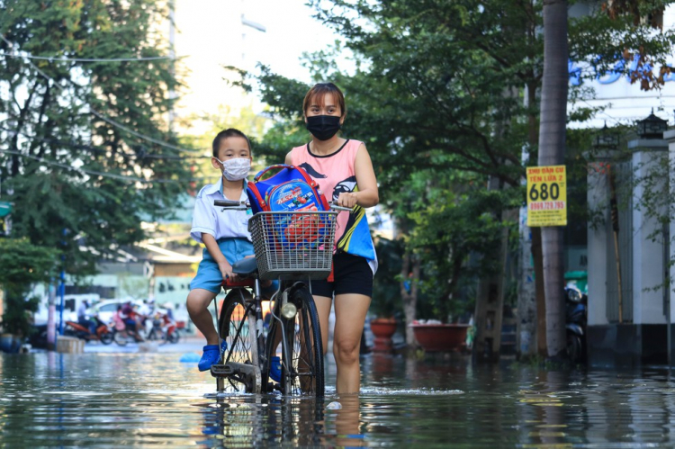 Người dân TP.HCM chèo xuồng đưa con đi học trong phố vì ngập mãi không hết