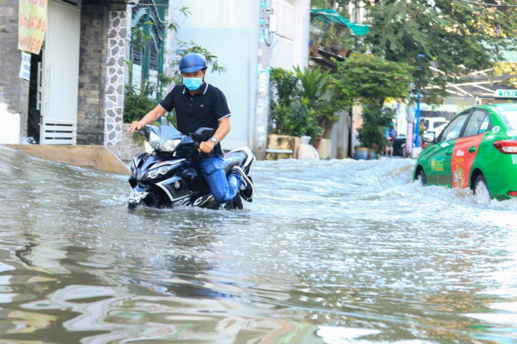 Người dân TP.HCM chèo xuồng đưa con đi học trong phố vì ngập mãi không hết