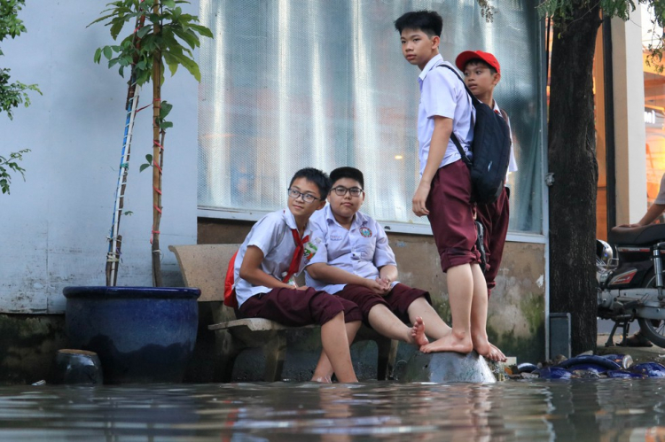 Người dân TP.HCM chèo xuồng đưa con đi học trong phố vì ngập mãi không hết